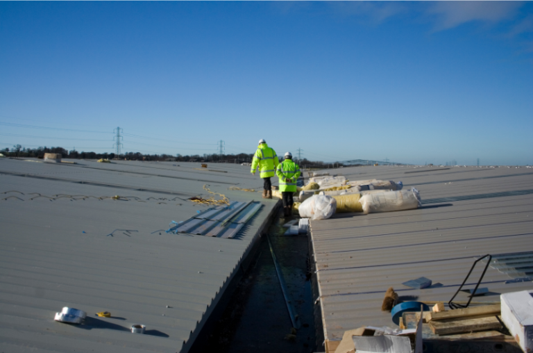 Two roofing contractors inspecting a commercial roof