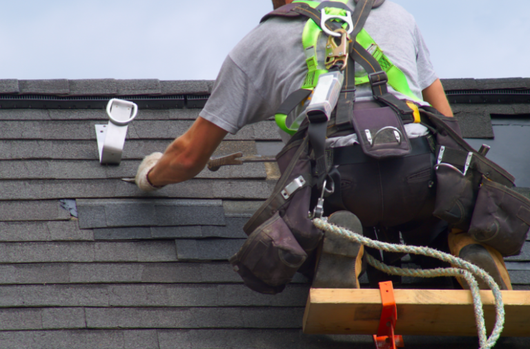 A roofer repairing the roof shingle