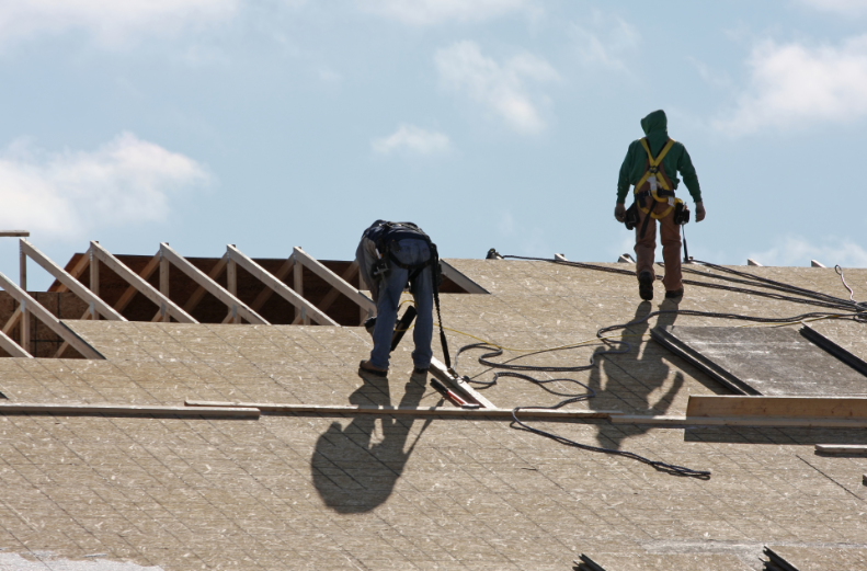 Two roofing contractors working on a roofing construction