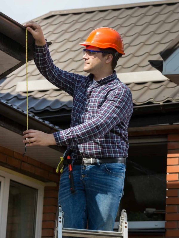 professional-worker-measuring-height-of-roof-with-tape.jpg